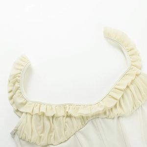 Detail of cream white corset top with mesh ruffle neckline and smooth slim-fit fabric