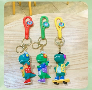 Close-up of cartoon dinosaur keychains with colorful braided straps on a wood table