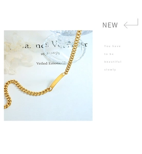 Close-up of golden Cuban chain with polished rectangular bar on a minimalist background