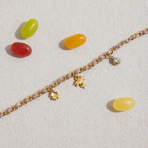 Detail of 18K gold stainless steel bracelet with clover, palm tree, and diamond charms