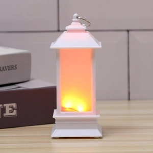 Detail of white Christmas lantern with warm LED flame light on wooden tabletop
