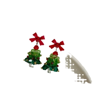 Handmade beaded crystal Christmas tree earrings with a red bow on white background