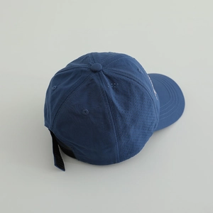 Detail of dark blue quick-dry baseball cap featuring laser-cut side vents and velcro strap