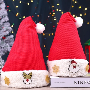 Bonnet de Noël tricoté avec motifs Père Noël sur magazine avec lumières bokeh