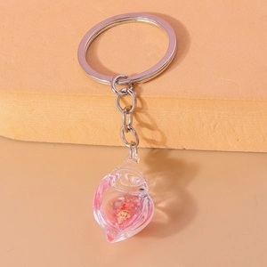 Detailed macro view of conch shell keychain with pink liquid and micro shell inside