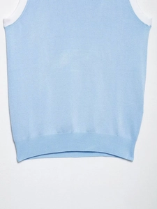 Gros plan du débardeur en maille bleu ciel avec col côtelé blanc et texture fine