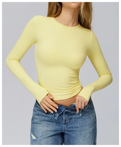 Close-up of light yellow brushed long sleeve yoga top with high elastic slim fit design