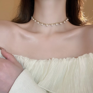 Elegant gold choker necklace featuring dainty imitation pearls for a minimalist wave design