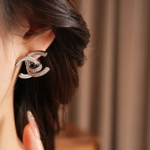 Close-up of 18k gold plated double-C earrings with sparkling cubic zirconia on ear