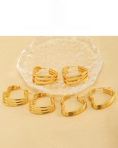 Détail de boucles d'oreilles cœur à trois couches plaquées or 18 carats sur plateau