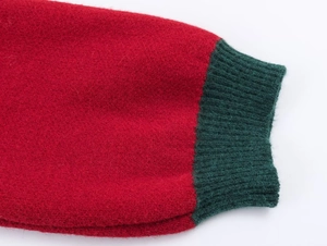 Detailed view of red knit sleeve with green ribbed cuff showing high-quality fabric texture