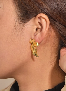 Close-up of elegant gold-plated flower stud earrings on model with metallic finish