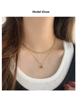 Close-up of 18K gold-plated double-layer necklace with elegant beads on model's neck