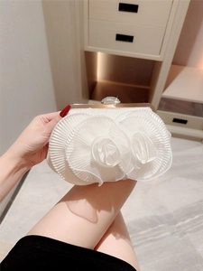 White 3D floral evening clutch bag with gold frame and diamond clasp shown in hand