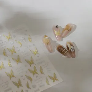 Macro shot of 3D yellow butterfly nail art stickers with elegant floral and pearl details