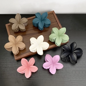 Matte flower hair claws in eight Morandi colors displayed on a wooden tray