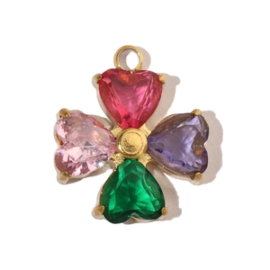 Detailed close-up of a golden clover pendant with four heart-shaped zircon stones