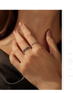 Detail of stacked S925 sterling silver beaded and hollow mesh rings on female fingers
