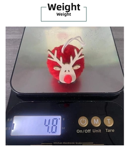 Detail shot of a red pompom reindeer ornament on an electronic scale showing 4.8g weight