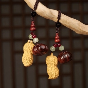Handcrafted wooden peanut and gourd car keychain with vintage beads on a rustic display