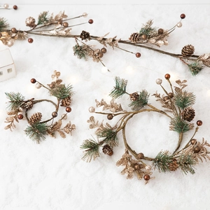 Golden pinecone Christmas wreath with pine needles and glitter leaves on snowy background