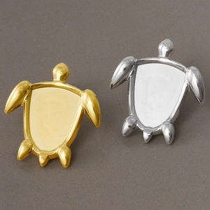 Detailed macro view of gold and silver turtle-shaped jewelry settings for DIY crafts