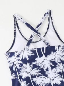 Macro view of adjustable criss-cross straps and navy tropical coconut tree print tankini
