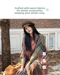 Close-up of colorful wavy knit shawl with fringe and casual winter hat in nature