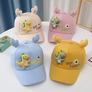 Detailed flat lay of colorful cotton caps featuring 3D dinosaur accents and embroidery