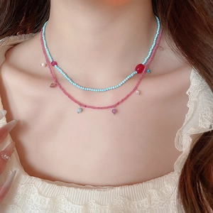 Close-up of bohemian double-layer beaded necklace with blue and pink pearls on neck