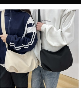 Detailed comparison of minimalist dumpling shoulder bag worn by male and female models