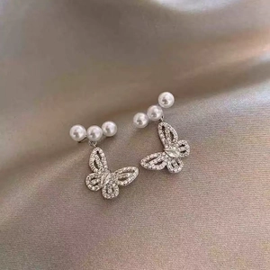 Detail of silver S925 butterfly stud earrings with crystal pave and three white pearls
