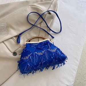 Detail of a navy blue sequined evening bag with tassels and metallic round handles