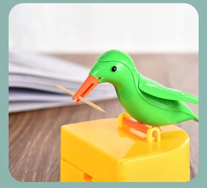Close-up of bird-shaped toothpick holder picking up a single wooden toothpick