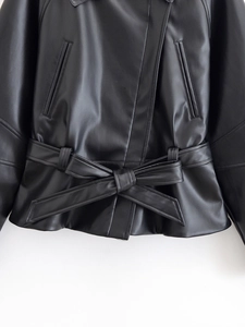 Detail shot of the waist area on a black leather jacket featuring a stylish bow-tie belt