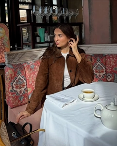 Detail of retro brown suede jacket showing lapel design and vintage casual texture