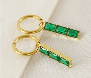 Detail of 18K gold-plated stainless steel hoop earrings with green rectangular zirconia