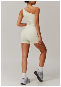 Détail d'un ensemble de yoga beige clair avec haut asymétrique et short de cyclisme