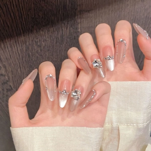 Macro detail of almond press-on nails with rhinestones, cat-eye finish and luxury pink gradient