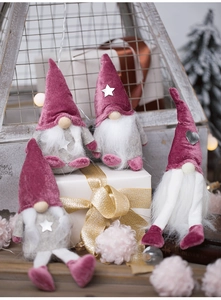 Cozy scene featuring burgundy and grey plush Christmas gnomes with warm festive lighting