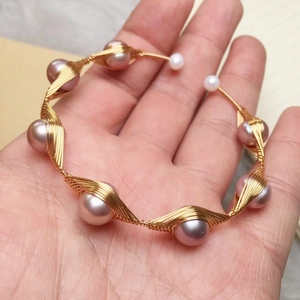 Detail of handmade 14K gold wire wrapped freshwater pearl cuff bracelet for women