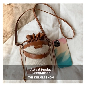 Detail of mini canvas bucket bag showing drawstring closure and leather logo patch