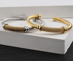 Macro shot of 18K gold mesh woven stainless steel cable cuff bracelets on minimal stones