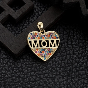 Macro shot of gold heart pendant with multicolor stones and cutout MOM lettering