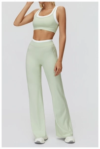 Détail du pantalon de yoga évasé à taille haute et haut de sport vert clair à liseré blanc