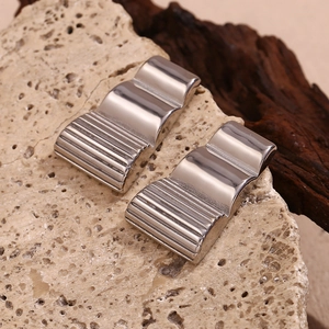 Macro shot of silver stainless steel trapezoid earrings with vertical wavy textured patterns