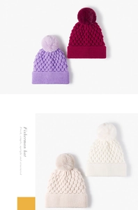 Detailed close-up of thick knit beanies with faux fur pom-poms in four elegant colors