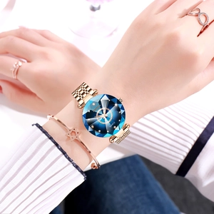 Detail of rose gold quartz watch with faceted blue glass dial and matching jewelry