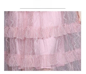 Detail eines rosa gestuften Spitzenkleids mit zarten Wellenstickereien und Rüschennetz