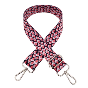 Detail of colorful geometric peacock pattern bag strap with silver metal swivel hooks
